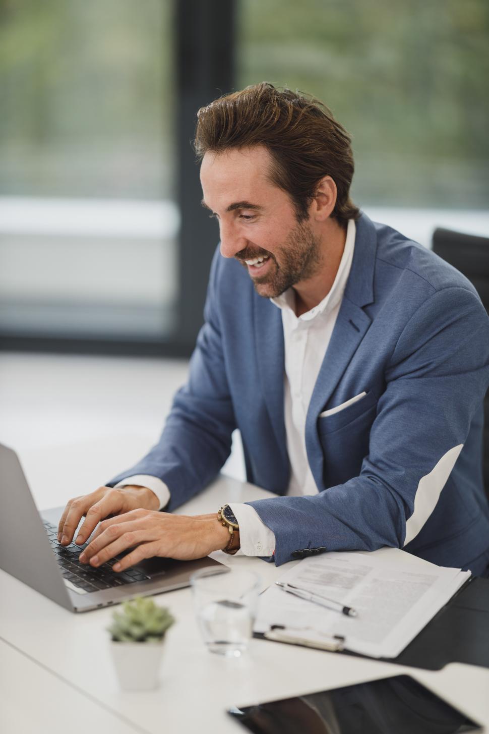 パソコンに向かって笑顔で働くビジネスパーソン